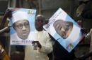 Supporters of presidential candidate Buhari hold his election posters in Kano