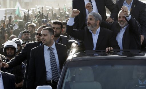 Hamas chief Meshaal, riding in a car with senior Hamas leader Haniyeh, gestures to the crowd upon his arrival in the southern Gaza Strip