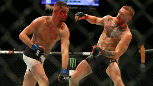 Nate Diaz rocks Conor McGregor with a punch during their UFC 196 fight. (Getty)
