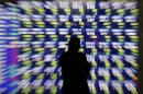A man looks at at an electronic stock quotation board outside a brokerage in Tokyo