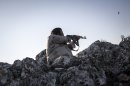 In this Sunday, Sept. 29, 2013 photo, a Free Syrian Army fighter aims his weapon towards government forces during clashes in Telata village, a frontline located at the top of a mountain in the Idlib, a northwest province countryside of Syria. (AP Photo)