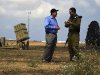 U.S ambassador to Israel Shapiro listens to an Israeli army colonel as they stand next to a launcher in a field near the southern city of Ashkelon