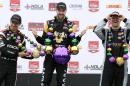 Winner James Hinchcliffe, center, of Canada, runner up Helio Castroneves, left, of Brazil, and third place finisher James Jakes, of England, celebrate with Mardi Gras beads after the IndyCar Grand Prix of Louisiana auto race, Sunday, April 12, 2015, in Avondale, La. (AP Photo/Jonathan Bachman)