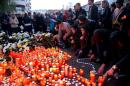 People light candles to commemorate the victims outside the nightclub Colectiv in Bucharest on October 31, 2015, a day after a deadly fire