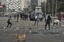 Egyptian students of the al-Azhar university throw stones at riot police outside their university camps in Cairo, on October 20, 2013