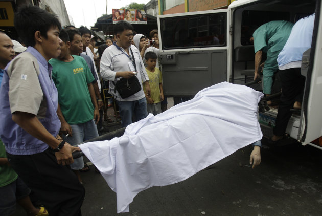 Funeral workers carry the body of a man who was recovered from the rubble of a collapsed wall in suburban Novaliches, Quezon City, Philippines, Sunday Aug. 28, 2011. Slow-moving Typhoon Nanmadol remai