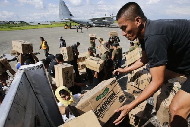 Philippine Army personnel unload relief goods at an airport in Mindanao on December 15, 2012. Typhoon Bopha killed 1,020 people, mostly on Mindanao island, where floods and landslides caused major damage on December 4, civil defence chief Benito Ramos said