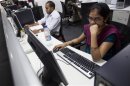 Employees work on their computer terminals on the floor of an outsourcing centre in Bangalore