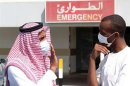 Men wearing surgical masks as a precautionary measure against the novel coronavirus, speak at a hospital in Khobar city in Dammam