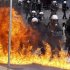 A petrol bomb explodes near riot police during protests against planned reforms by Greece's coalition government in Athens
