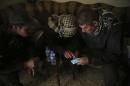 Special forces Lt. Col. Ali Hussein, right, listens to an Iraqi informant, center, giving information about Islamic State militant positions on a mobile map, in the Bakr front line neighborhood, in Mosul, Iraq, Friday Nov. 25, 2016. Iraqi special forces fought house to house in Mosul, while focusing efforts on winning hearts and minds among civilians and gleaning information about Islamic State militants holed up in buildings sometimes just a block away. (AP Photo/Hussein Malla)