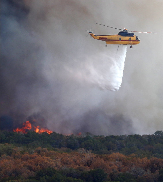 A helicopter begins to drop water on a wildfire at Possum Kingdom Lake, Texas, Wednesday, Aug. 31, 2011.   Texas and Oklahoma are in the grips of a record-setting drought, and a summer of soaring temp
