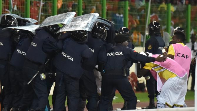 Ghana&#39;s national football team players leave the pitch protected by riot police at the half-time of the 2015 African Cup of Nations semi-final football match between Equatorial Guinea and Ghana in Malabo, on February 5, 2015