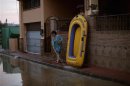 A woman cleans the entrance of her home of mud after heavy rain in the neighborhood of Santa Amalia in Alhaurin de la Torre, near Malaga southern Spain