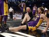 Los Angeles Lakers' Gasol sits on the floor with a member of the Lakers medical staff after suffering an injury to his right leg in the fourth quarter of their NBA basketball game against the Brooklyn
