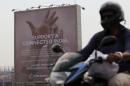 A motorist rides past a billboard displaying Facebook's Free Basics initiative in Mumbai, India