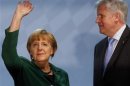 German Chancellor Merkel waves next to Bavarian Prime Minister Seehofer before her guest speech at CSU party meeting in Munich