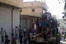 Crowds greet Syrian rebels as they parade through a street atop a tank in Al-Bab in the northern province of Aleppo