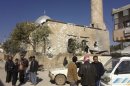 Residents are seen near a damaged mosque after heavy shelling by government forces in Sermeen, near the northern city of Idlib