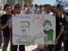 In this citizen journalism image made on a mobile phone and provided by Shaam News Network, anti-Syrian President Bashar Assad protesters, hold a cartoon placard depicting Moammar Gadhafi, right, and Syrian President Bashar Assad, left, with Arabic words read:"step back," during a demonstration against the Syrian regime, at Maaret Harma village, in Edlib province, Syria, on Friday Aug. 26, 2011. Syrian security forces killed at least two people as tens of thousands of anti-government protesters flooded the streets on the last Friday of the holy month of Ramadan, a time that many activists hoped would become a turning point in the uprising. (AP Photo/Shaam News Network) EDITORIAL USE ONLY, NO SALES, THE ASSOCIATED PRESS IS UNABLE TO INDEPENDENTLY VERIFY THE AUTHENTICITY, CONTENT, LOCATION OR DATE OF THIS HANDOUT PHOTO