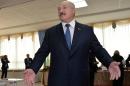 Belarus' President Alexander Lukashenko speaks with journalists during presidential elections at a polling station in Minsk on October 11, 2015