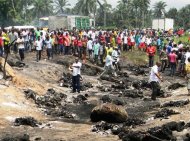 Ciudadanos nigerianos observan el lugar de la explisin este jueves en Okogbe. Ms de 100 personas que trataban de extraer gasolina de un camin cisterna volcado murieron este jueves cuando el vehculo se incendi y estall, declar a la AFP el comisionado de seguridad del estado de Ros (sur de Nigeria)