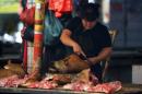 A woman cuts dog meat at a market in Yulin, south China's Guangxi province, on June 18, 2014