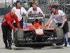 Crew members push the car of Marussia Formula One driver Chilton after it stalled on the track during the second practice session of the Chinese F1 Grand Prix at the Shanghai International circuit