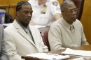 FILE - In this file photo of June 6, 2013, Vincent George Jr., left, and Vincent George Sr., listen to closing arguments in a courtroom in New York. The father and son who acknowledged they were pimps were sentenced on Monday July 8, 2013, to three to nine years in prison for promoting prostitution and money laundering. They were acquitted earlier of sex trafficking charges after several prostitutes testified they were treated well. (AP Photo/Seth Wenig, File)
