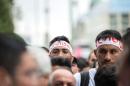 Yazidi refugees from Iraq wear headbands written with 'Shingal' (the Kurdish name for the northern Iraqi city of Sinjar) at a march commemorating the attack on religious and ethnic minorities by the Islamic State group in northern Iraq in 2014, Wednesday, Aug. 3, 2016, in Berlin Germany. (Wolfram Kastl/dpa via AP)