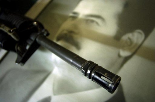 بندقية على صورة لصدام حسين
