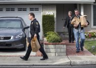 Police investigators take away evidence from the home of the mother of fugitive suspect former Los Angeles police officer Christopher Dorner, in La Palma, Calif., on Friday, Feb. 8, 2013. Police agencies have launched a massive manhunt for Dorner, who is suspected of killing a couple over the weekend and opening fire on four officers early Thursday, killing one and critically wounding another, authorities said. (AP Photo/Damian Dovarganes)