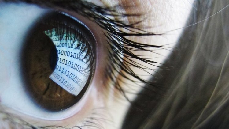 Binary code reflected from a computer screen in a woman's eye on October 22, 2012