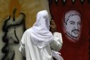 A Bahraini man looks at an image of jailed hunger striker Abdulhadi al-Khawaja painted on a wall in Barbar, Bahrain, west of the capital of Manama, on Monday, April 30, 2012. A defense lawyer says a Bahrain appeals court has ordered the reexamination of the case of al-Khawaja and more than a dozen others. (AP Photo/Hasan Jamali)