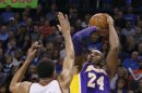 Los Angeles Lakers guard Kobe Bryant shoots against Oklahoma City Thunder guard Thabo Sefolosha of Switzerland, in the first half of NBA basketball game in Oklahoma City.