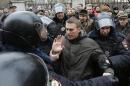 Police detain opposition leader Alexei Navalny outside a courthouse in Moscow