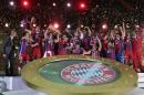 The team of German soccer club Bayern Munich celebrates with the trophy after winning the German Soccer Cup Final between FC Bayern Munich and Borussia Dortmund at the Olympic Stadium Berlin, Germany, Saturday, May 17, 2014. (AP Photo/Markus Schreiber)