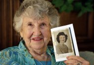In this Thursday, May 23, 2013 photo, Laura Mae Davis Burlingame, 90, holds a photo of herself from high school, in her Moorseville, Ind. home. The photo filled the back cover of a diary she had given to a Marine Cpl. Thomas “Cotton” Jones, a 22-year-old machine gunner, who died in the bloody assault on a Japanese-held island during World War II. Burlingame didn’t know the military diary she gave Jones had survived him. She saw it and read, “If this Diary is lost and if it is Possible please return it to Miss Laura Mae Davis. Address. Winslow Indiana.” (AP Photo/Michael Conroy)