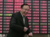 An investor smiles in front of the stock price monitor at a private securities company Wednesday, April 18, 2012 in Shanghai, China. Asian stocks were catapulted higher Wednesday by speculation that Japan might take measures to spur its economy, but European shares scaled back a day after posting strong gains. (AP Photo)