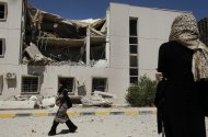 In this photo taken on a government-organized tour Libyan students walk past the damaged university building in Tripoli, Libya, on Saturday, June 18, 2011. Libyan officials claim that one of the buildings at the university complex was recently hit by a NATO airstrike. (AP Photo/Ivan Sekretarev)