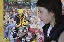 A woman walks past a poster of animation "Assassination Classroom" in Tokyo, Saturday, Jan. 31, 2015. Images or mentions of knives, ransom or blood - or anything else that can be seen alluding to the hostage crisis involving two Japanese in Syria - have been cut out. Some anime and other entertainment programs are altering, canceling or postponing episodes violating those sensitivities - typical of the kind of self-restraint shown here to avoid controversy. The following day, broadcaster Fuji Television Network canceled an episode of the animation, citing "inappropriate material given the current situation." (AP Photo/Koji Sasahara)