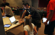 In this Aug. 23, 2011 photo, Eric Calandriello lends tech support to senior Jean Harafin, 17, after she and other students received iPads at Burlington High School in Burlington, Mass. Burlington is giving iPads this year to every one of its 1,000-plus high school students. Some classes will still have textbooks, but the majority of work and lessons will be on the iPads. (AP Photo/Elise Amendola)