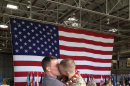 Sgt. Brandon Morgan, right, is embraced by his partner Dalan Wells in a helicopter hangar at a Marine base in Kaneohe Bay, Hawaii, upon returning from a six-month deployment to Afghanistan in this photo made Wednesday, Feb. 22, 2012. The photo, made some five months after the repeal of the military's 