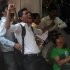 Indian fans celebrate as they watch Sachin Tendulkar score his 100th century on a television set inside a shop in Mumbai
