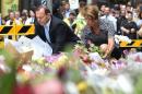 Australian Prime Minister Tony Abbott (L) and his wife Margaret lay wreaths at a makeshift memorial near the scene of a fatal siege in Sydney's financial district on December 16, 2014