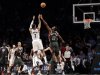 Brooklyn Nets guard Joe Johnson (7) scores over Milwaukee Bucks forward Luc Richard Mbah a Moute (12) with time expiring for a 113-11 overtime victory in their NBA basketball game at Barclays Center, Tuesday, Feb. 19, 2013 in New York. (AP Photo/Kathy Willens)