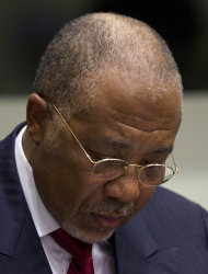 Former Liberian President Charles Taylor takes notes as he waits for the start of a hearing to deliver verdict in the court room of the Special Court for Sierra Leone in Leidschendam, near The Hague, Netherlands, Thursday April 26, 2012. Judges were expected to deliver landmark judgements in the trial against the former president who is charged with supporting notoriously brutal rebels in neighboring Sierra Leone. (AP Photo/Peter Dejong, Pool)