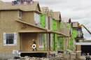 Construction workers work on building new homes in Calgary, Alberta