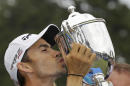 Camilo Villegas, of Colombia, kisses the Sam Snead trophy on the 18th green after winning the Wyndham Championship golf tournament in Greensboro, N.C., Sunday, Aug. 17, 2014. Villegas won the tournament with a 17 under-par 263. (AP Photo/Gerry Broome)
