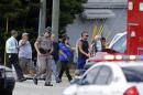 A Florida state trooper, center, escorts a group of parents to a day care center to pick up their children after a vehicle crashed into the center, Wednesday, April 9, 2014, in Winter Park, Fla. At least 15 people were injured, including children. (AP Photo/John Raoux)